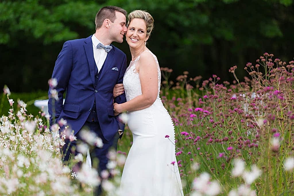 Romantic shot of birde and groom in flower field