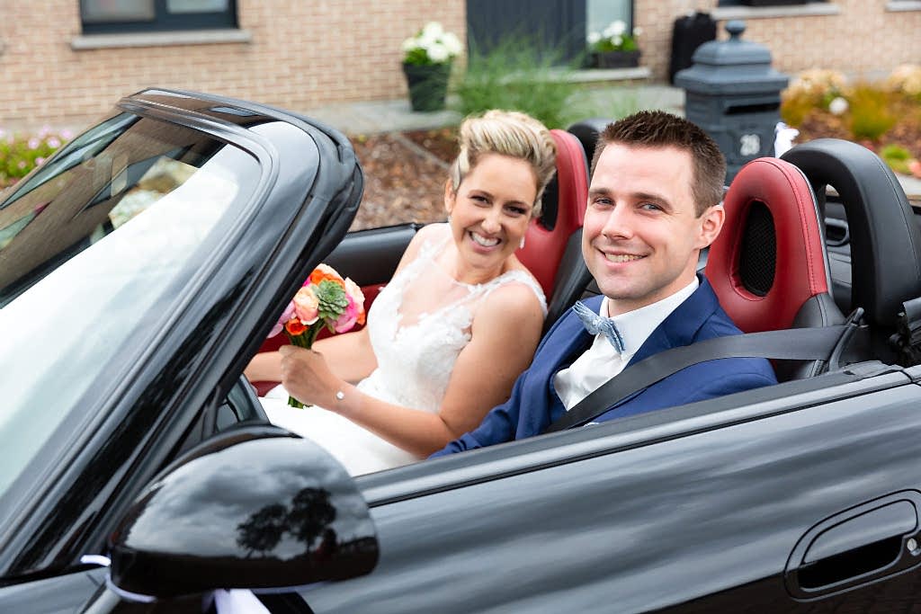 bride and groom in sports car