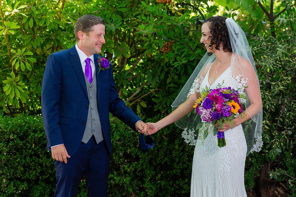 Bride and groom holding hands and smiling at each other