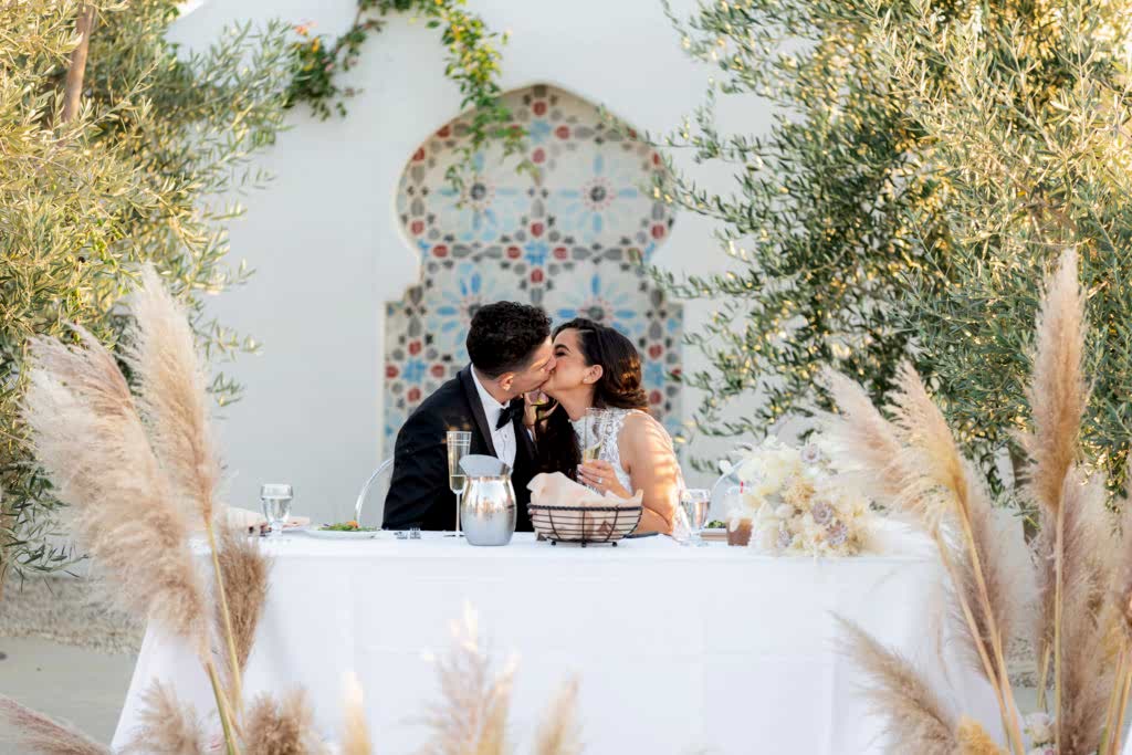 Malibu Estate Wedding couple kissing during dinner