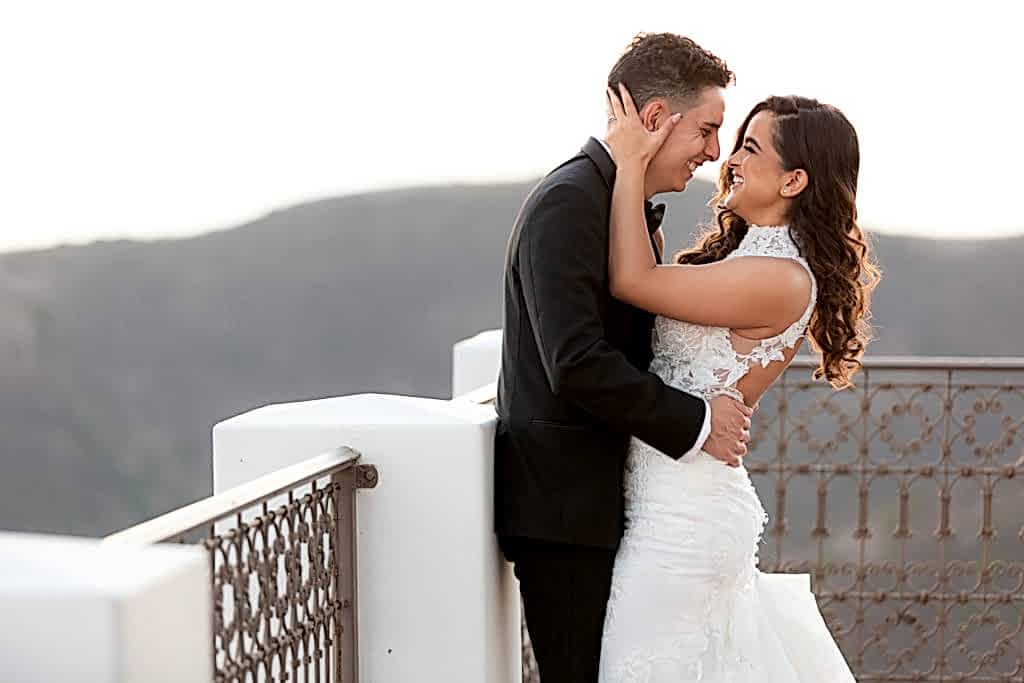 Malibu Estate Wedding couple kissing on balcony