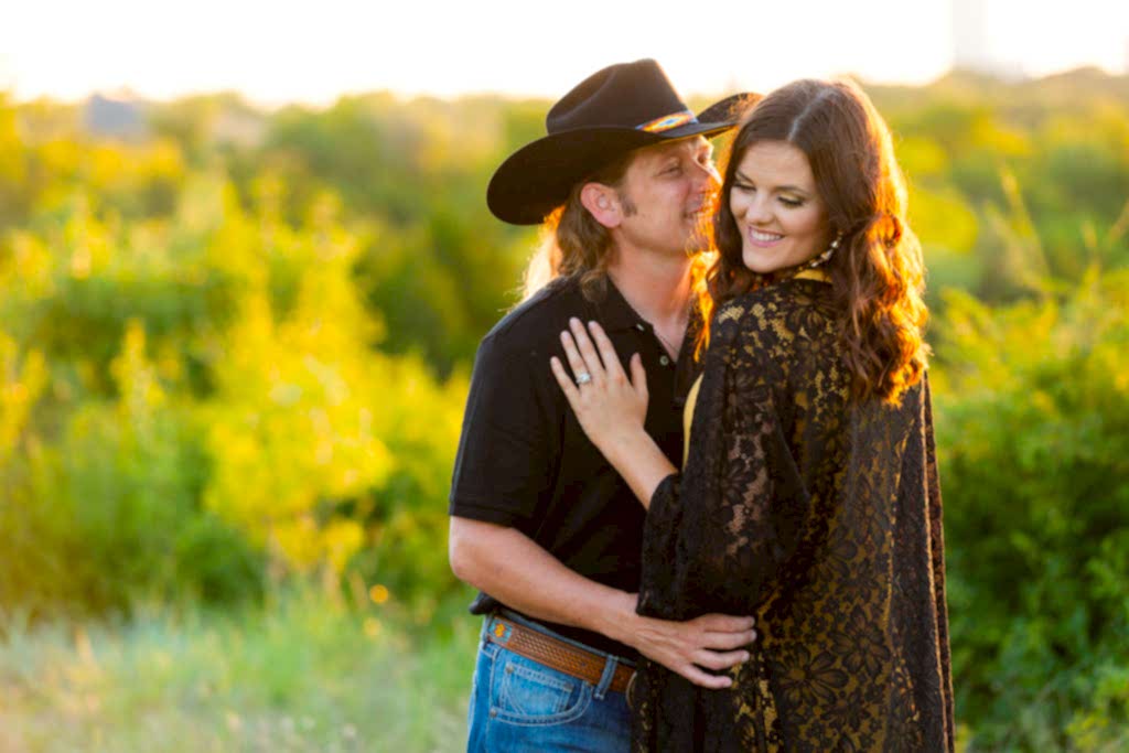 Cowboy smiling at fiancée during a Tandy Hills engagement session in Texas