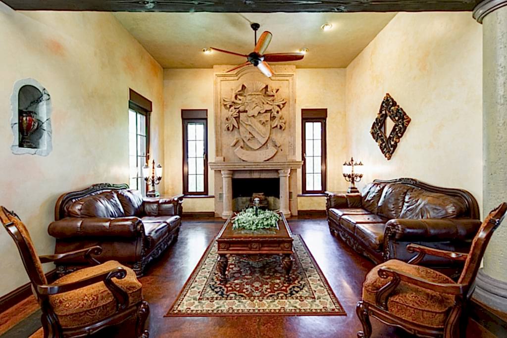 living room area in Stoney Ridge Villa wedding venue with dark leather couches and a stone fireplace