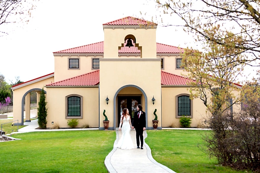 bride and groom holding hands and walking on the grounds of their Azle wedding venue, Stoney Ridge Villa