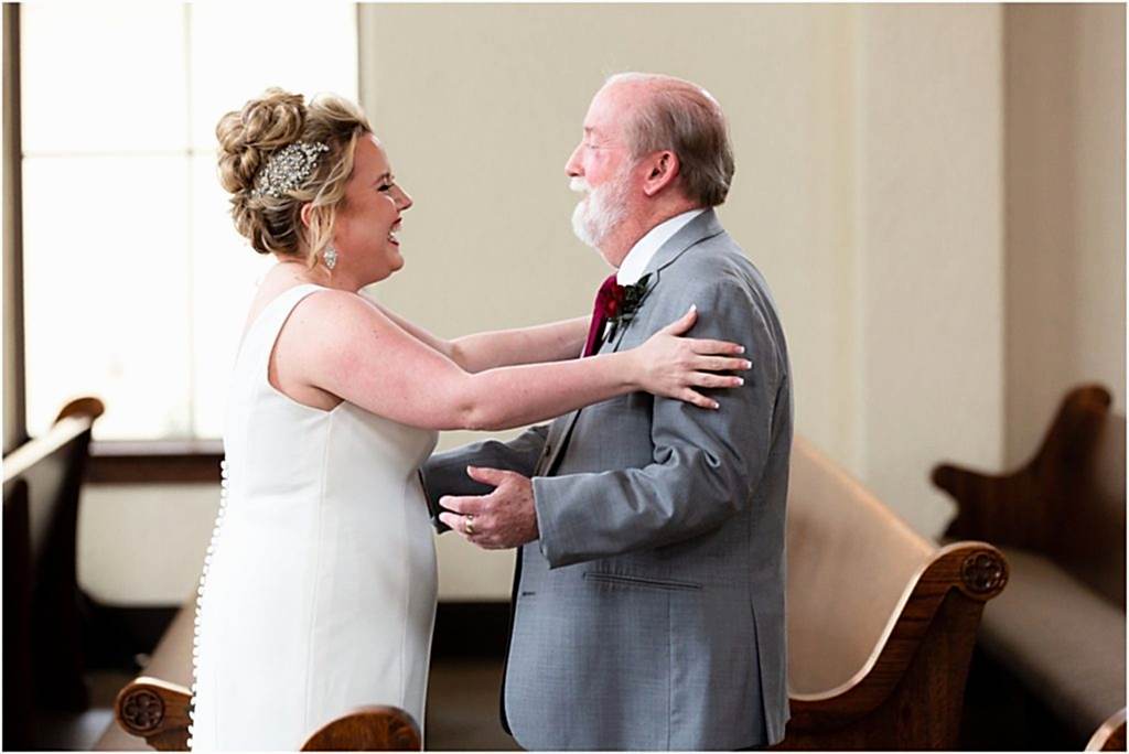 Dallas wedding photographer shoots a moment between bride and father of the bride as she stretches out her arms to embrace him