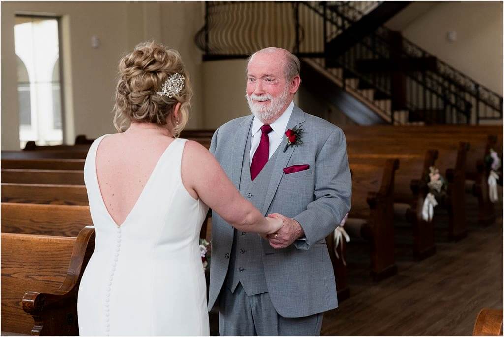 Dallas wedding photographer captures father of the bride getting emotional as he holds the hands of the bride in Ana Villa wedding venue