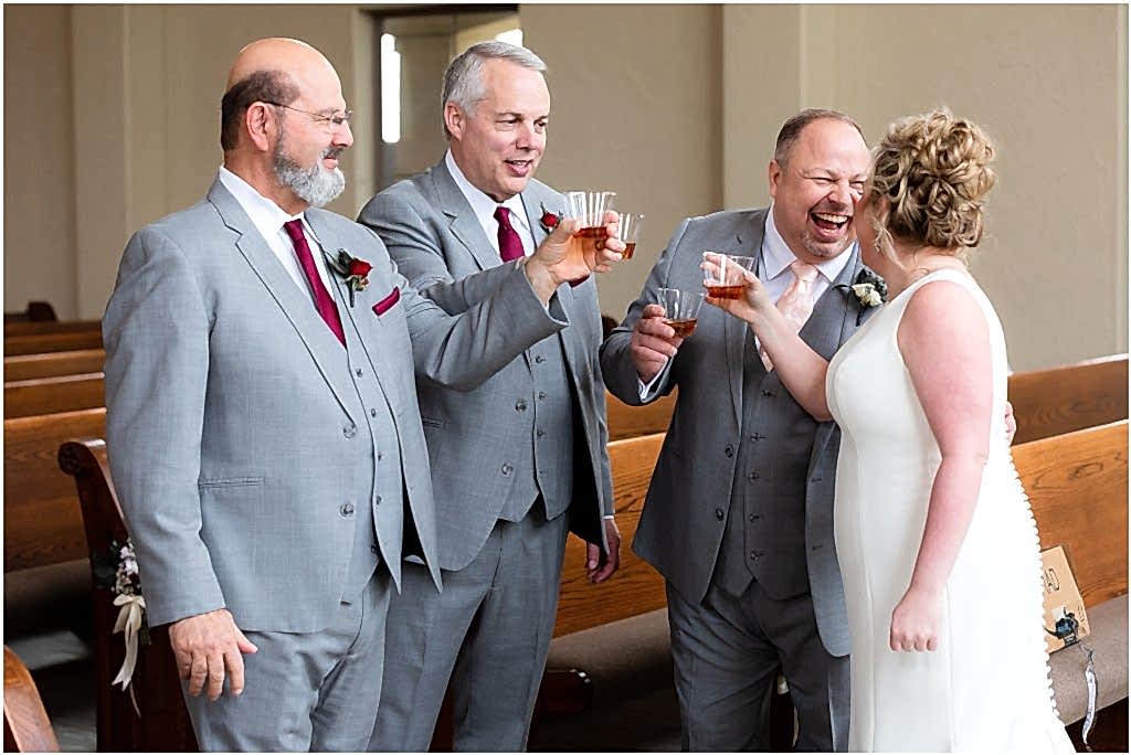 Two groomsmen, the groom, and the bride share a toast in the chapel of at Ana Villa wedding venue captured by Dallas wedding photographers