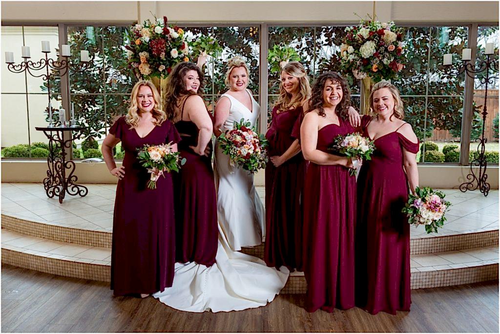 Dallas wedding photographers capture five bridesmaids posing with bride on the stairs of luxury wedding venue