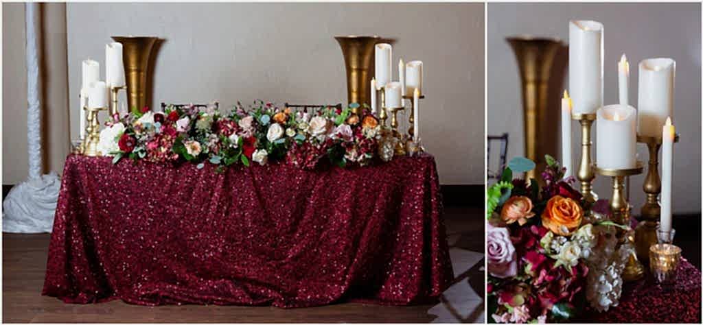 The head table decorated in maroon linens, extravagant florals, and white candles photographed by Dallas wedding photographers