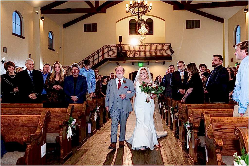 Full light bride and father of the bride walk up the aisle at the chapel at ana villa wedding ceremony site captured by Dallas wedding photographers