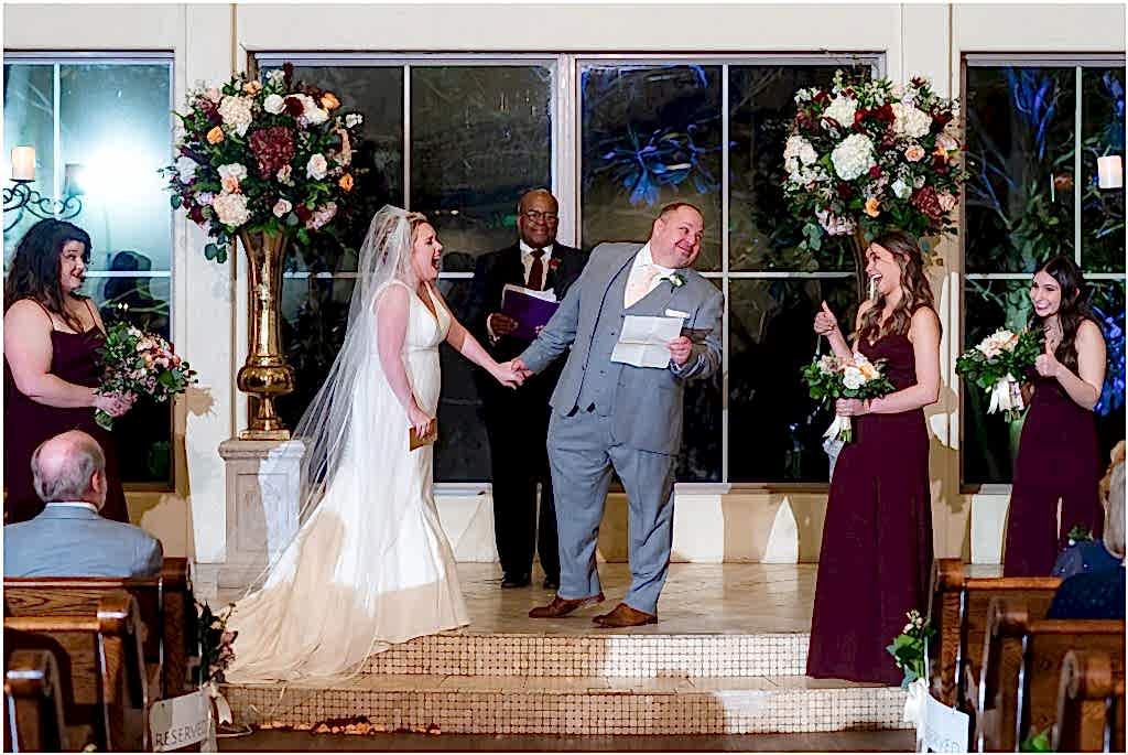 Groom leans over to daughter who gives a thumbs up during wedding ceremony captured by Dallas wedding photographers