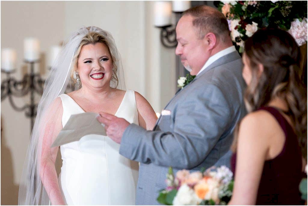 wedding ceremony with bride and groom reading their vows in an indoor wedding venue photographed by Dallas wedding photographers