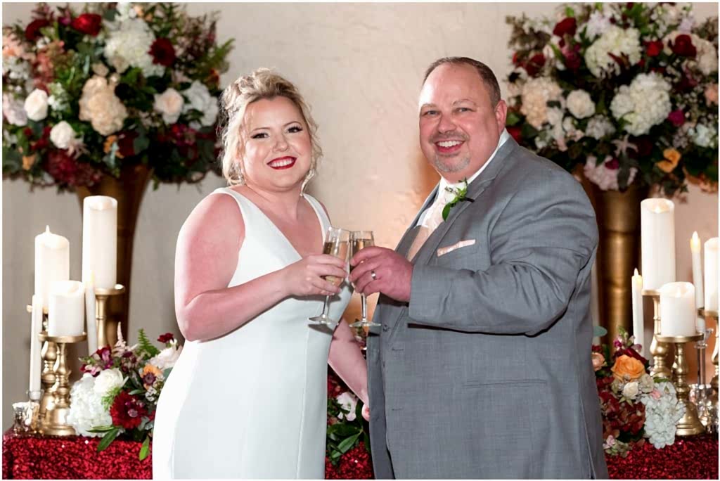Bride and groom pose with glasses of champagne to celebrate their Dallas TX wedding photographed by Dallas wedding photographers