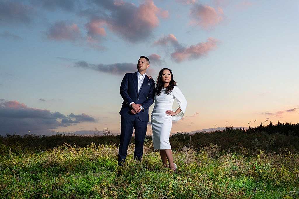 Engaged couple posing on top of hill with cotton candy sunset at Arbor Hills Nature Preserve for a Plano park engagement session