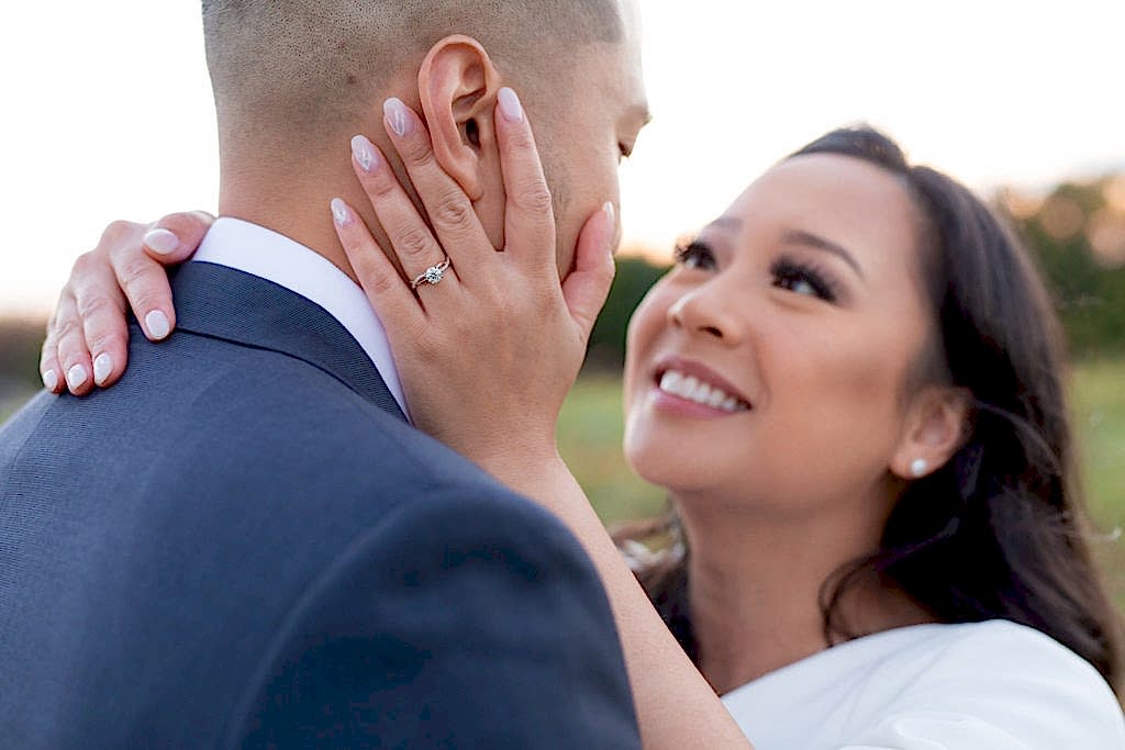 engagement ring shot with woman holding her grooms face for their outdoor engagement session