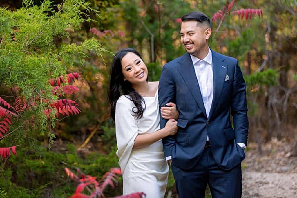 Engaged couple in red flowers at park in Plano