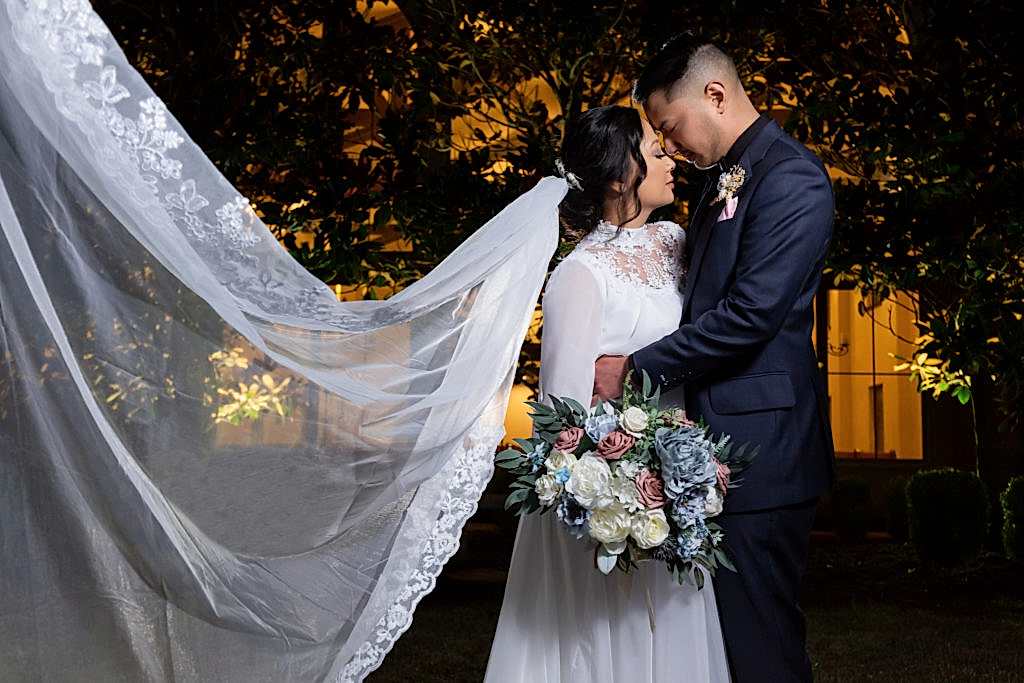 Bride and groom foreheads touching with veil flowing behind them in at Chapel at Ana Villa wedding venue