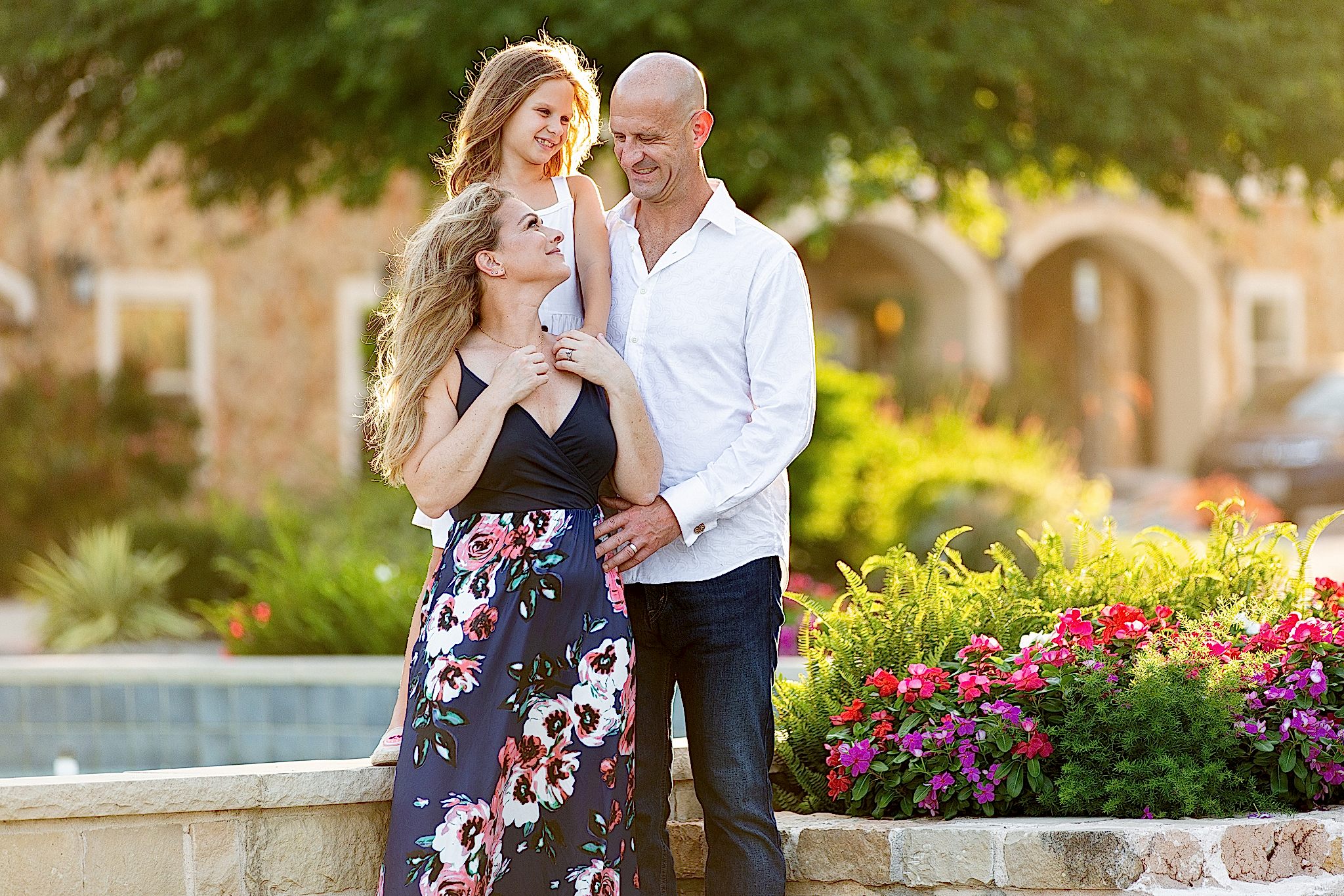 Family at golden hour smiling at each other surrounded by flowers at Adriatica Village