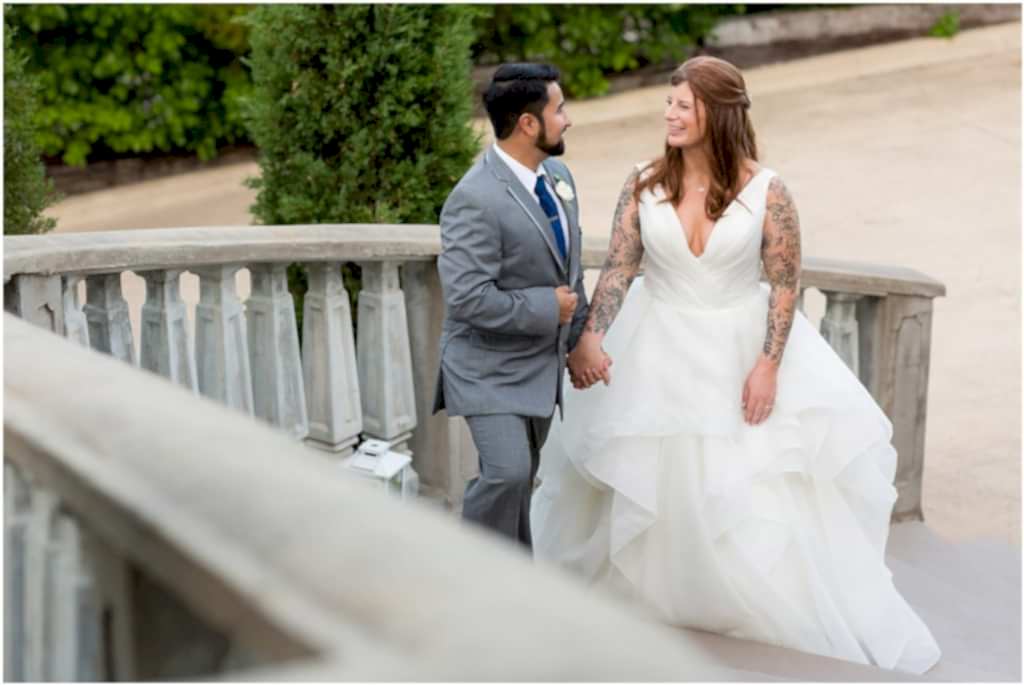 bride and groom holding hands and walking up a set of stone stairs at Azle texas wedding venue