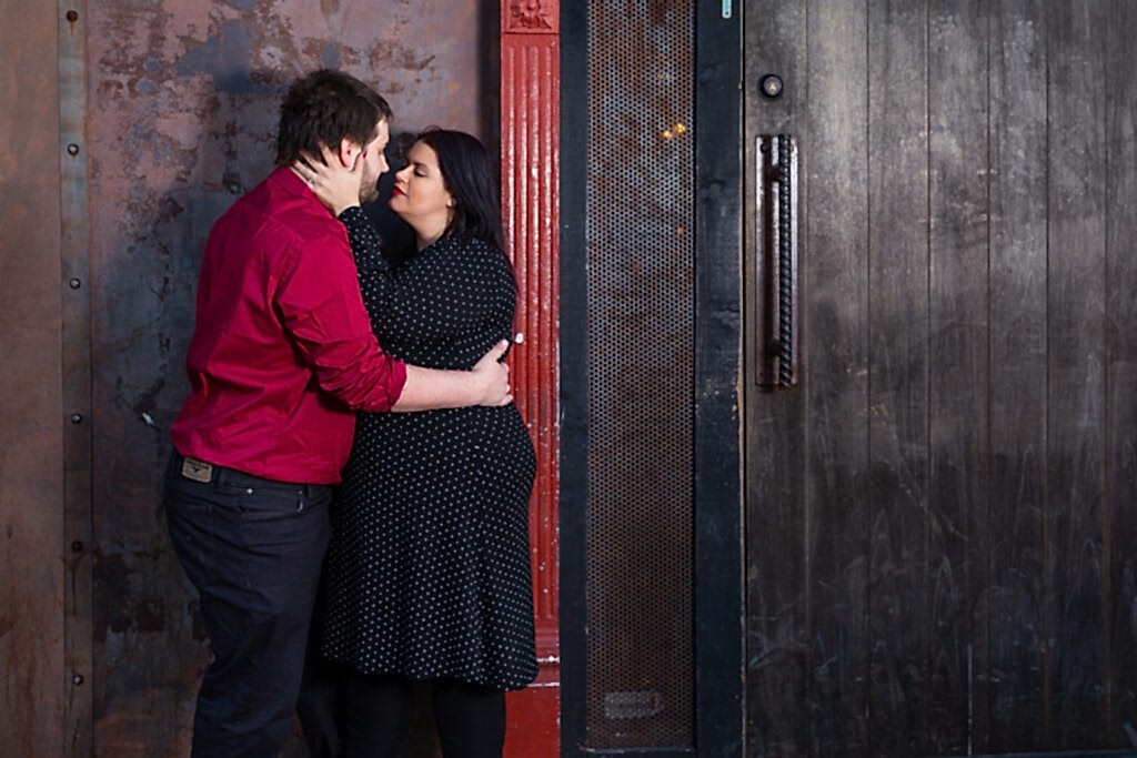Engaged man and woman embracing on street in Deep Ellum TX