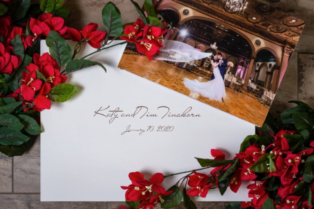 custom handcrafted italian wedding album with an acrylic photo cover lying on top of its heirloom white leather box