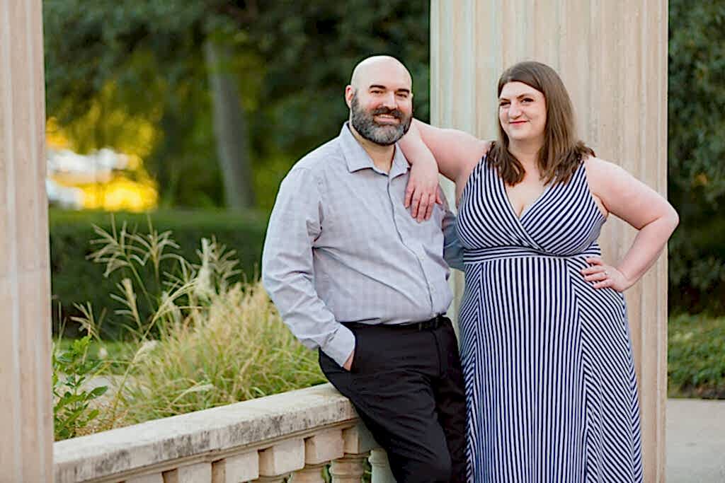 Woman leaning on man's shoulder smiling sweetly at the camera during engagement session at TWU in Texas