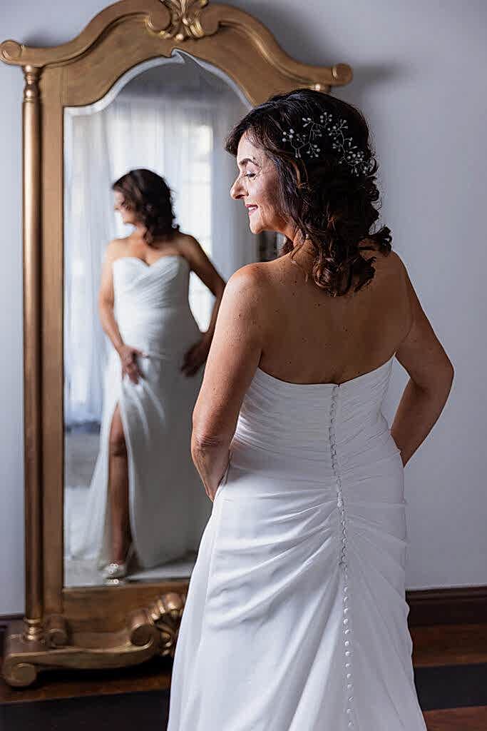 Bridal portrait of bride looking in mirror in bridal suite at Stoney Ridge Villa wedding venue