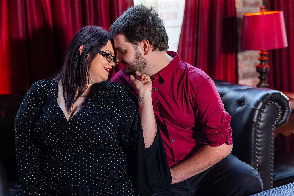 Dallas wedding photographer captures couple cozing up on couch during Deep Ellum bar engagement session