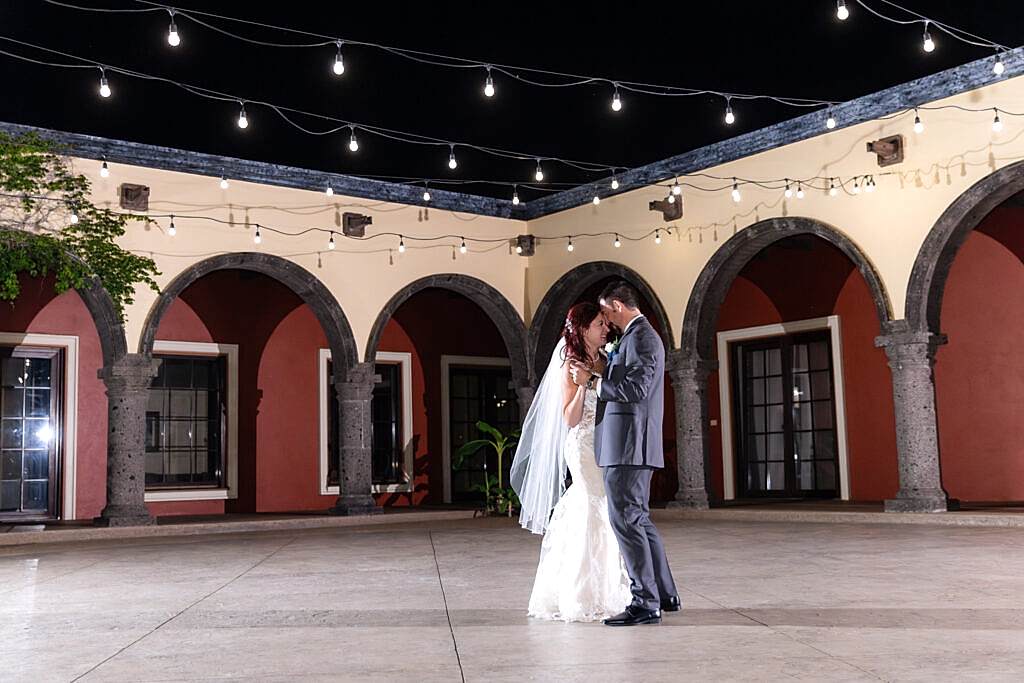 Bride and groom dancing intimately during private last dance in courtyard of Azle wedding venue