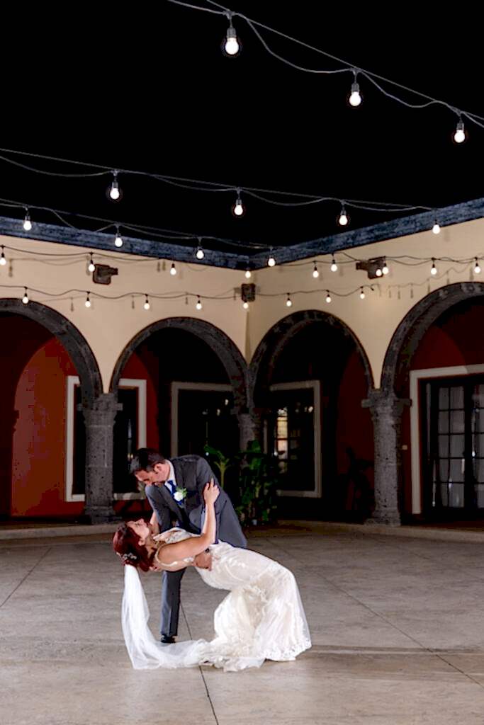Bride and groom dipping during private last dance in courtyard of Azle TX wedding villa