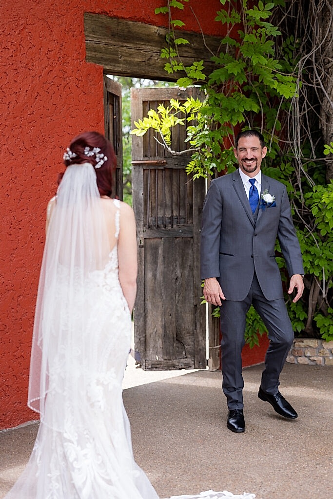 Groom turning around with a big smile to see bride during the first look