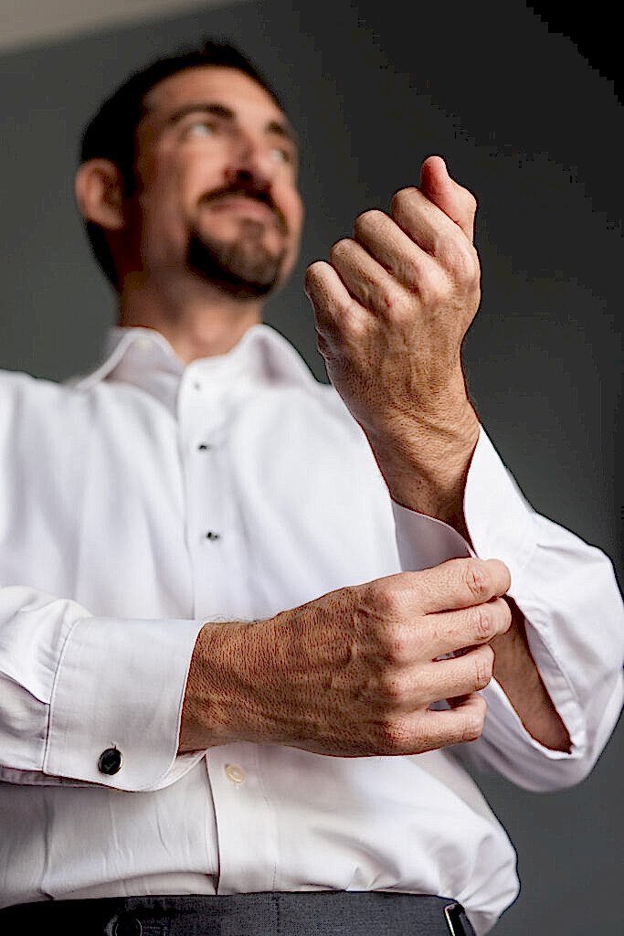 Groom putting on cufflinks