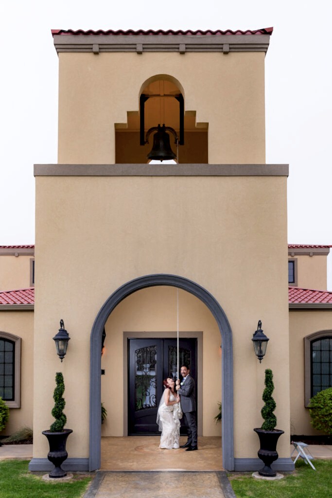Bride and groom pulling rope to bell tower at Azle TX wedding venue Stoney Ridge Villa