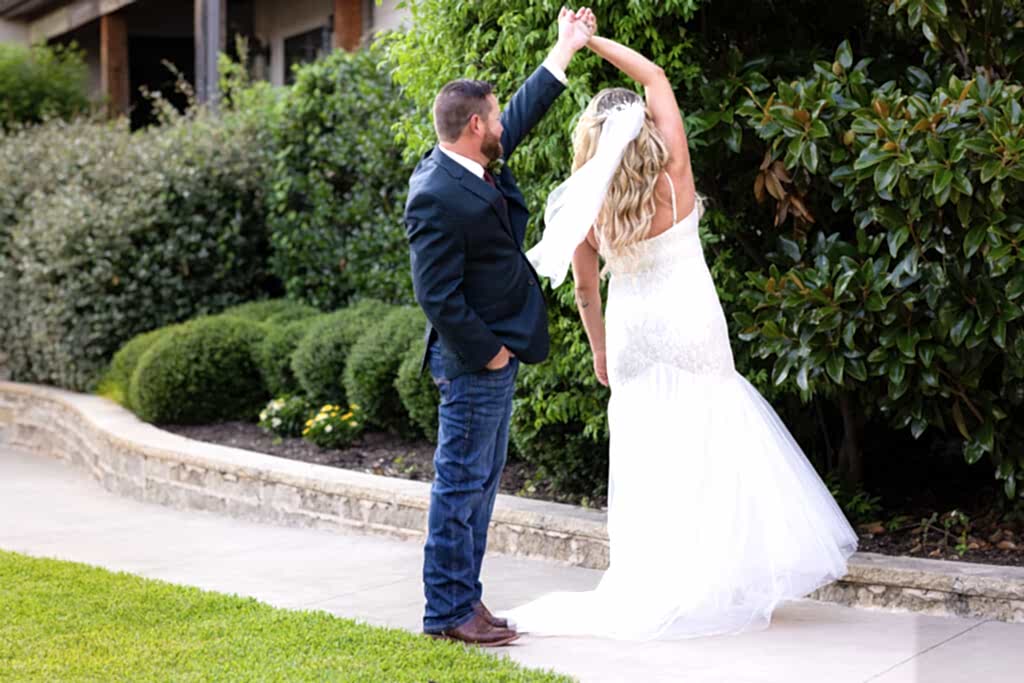 Wedding couple doing a twirl on walking path