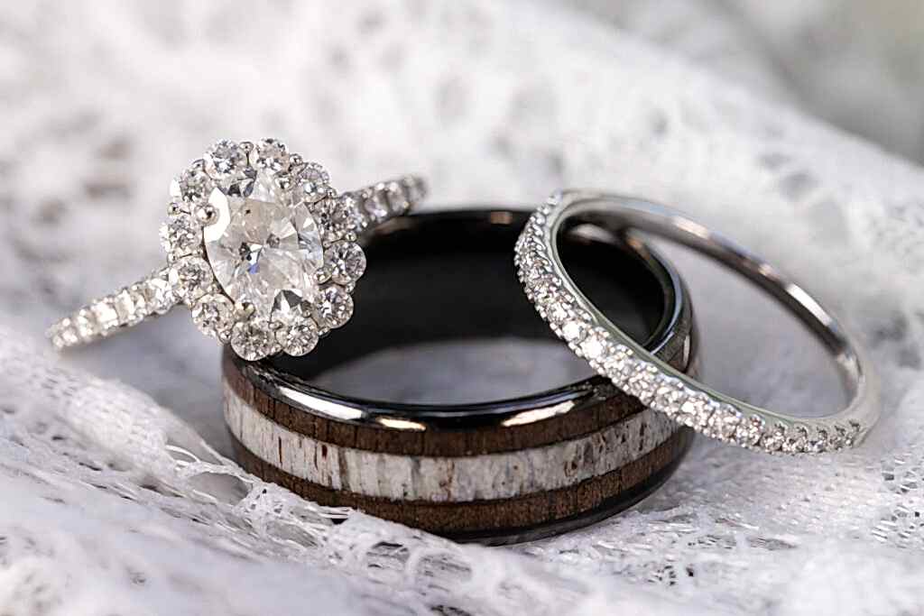 Diamond engagement ring, diamond wedding band and unique multi material wedding band against a lace backdrop