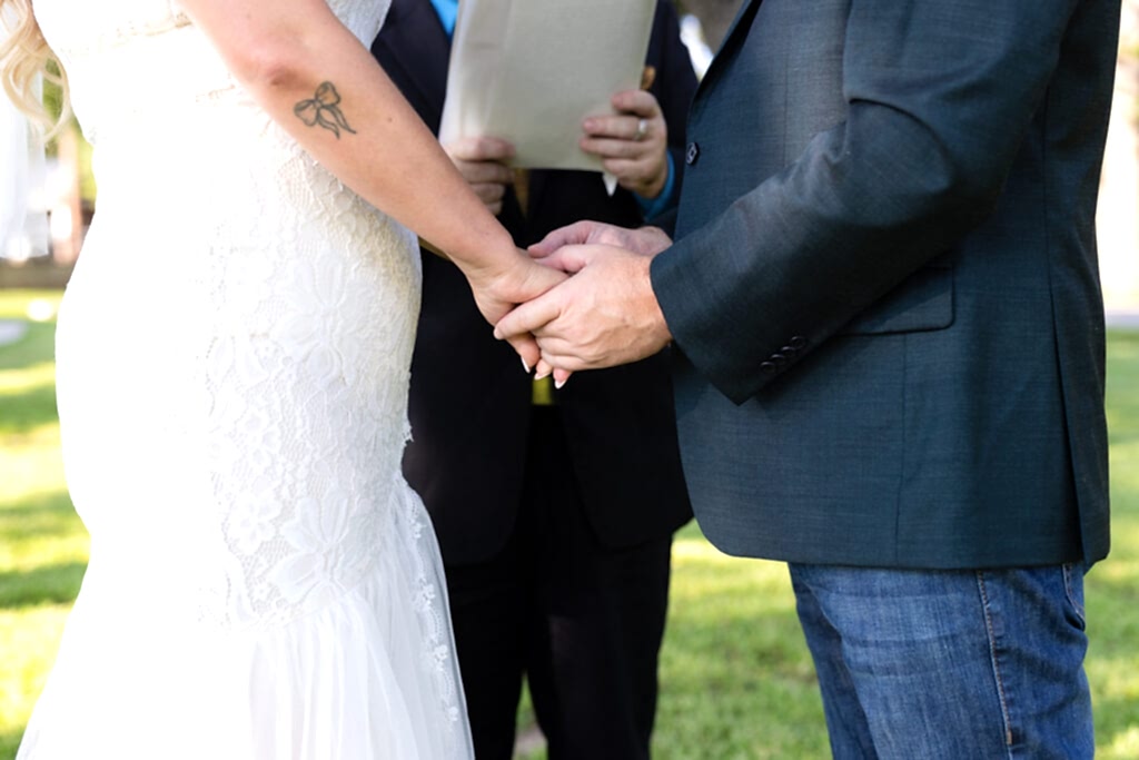 Bride and groom holding hands during wedding ceremony