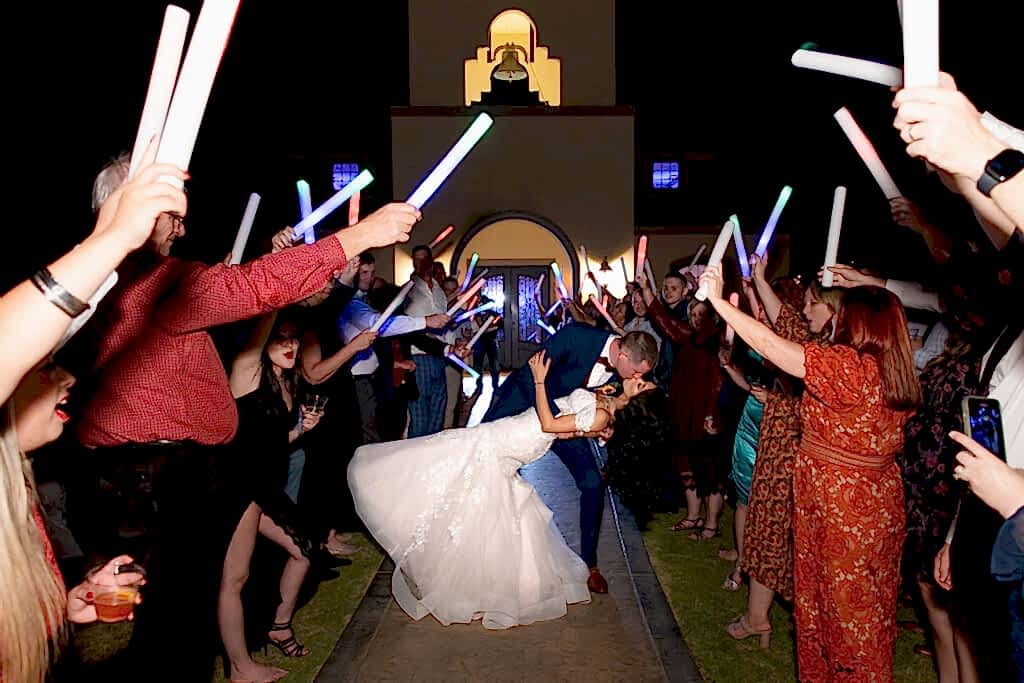Bride and groom dip during grand exit with glowsticks