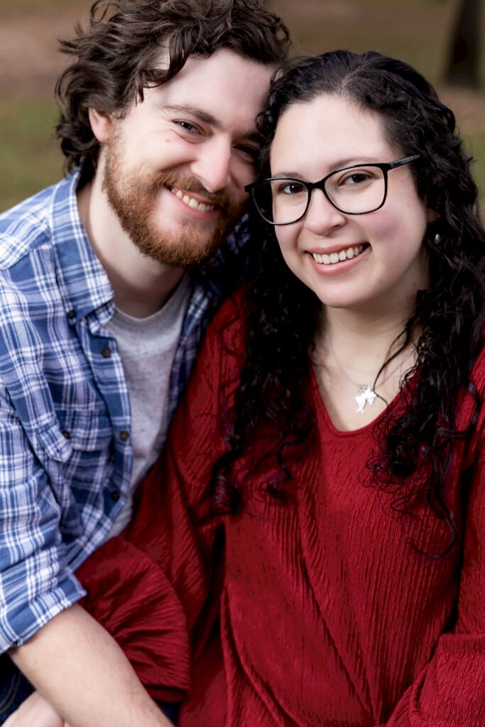 Engaged couple smiling at camera with heads together