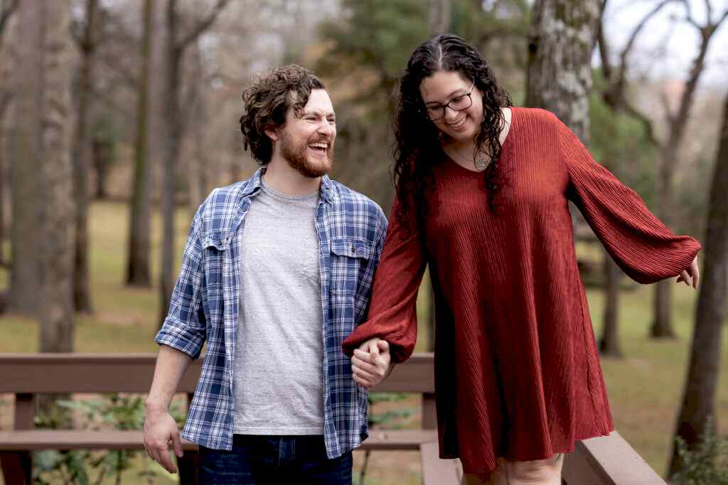 Man laughing towards fiancée while walking together