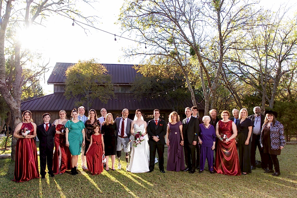 Large family photo in front of Taylor Barn at Bella Woods wedding venue nestled in the woods