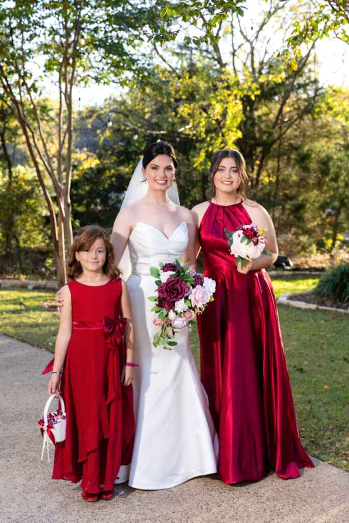 Bride and friends wearing red in the woods at Bella Woods wedding and event venue in Midlothian Texas